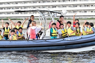 ボートに乗って芦屋について説明を受ける小学生ら＝芦屋市沖