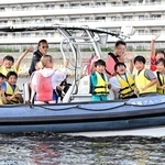 ボートに乗って芦屋について説明を受ける小学生ら＝芦屋市沖