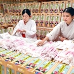 千歳あめを袋に詰める巫女＝西宮市社家町