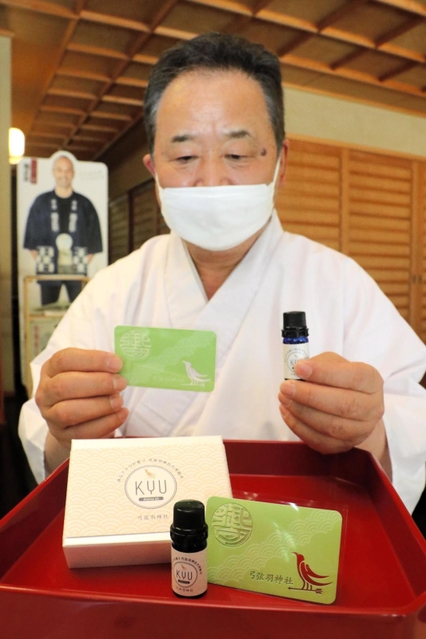 アロマオイルを垂らして持ち運ぶカードタイプのお守りと澤田政泰宮司＝神戸市東灘区御影郡家２