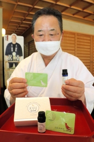 アロマオイルを垂らして持ち運ぶカードタイプのお守りと澤田政泰宮司＝神戸市東灘区御影郡家２