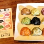 焼きたてのマカロンギョーザと、リーフレット。９色の並べる順は決まっており、リーフレットの裏面には食材を全て記載している＝神戸市東灘区深江北町１