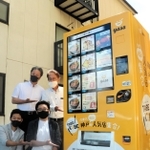 冷凍食品の自販機「ＴＡＢＥ　ＫＯＢＥ」（食べ神戸）の第１弾を設置した川原裕剛さん（２列目左）ら＝神戸市東灘区魚崎南町４のトミーズ魚崎本店