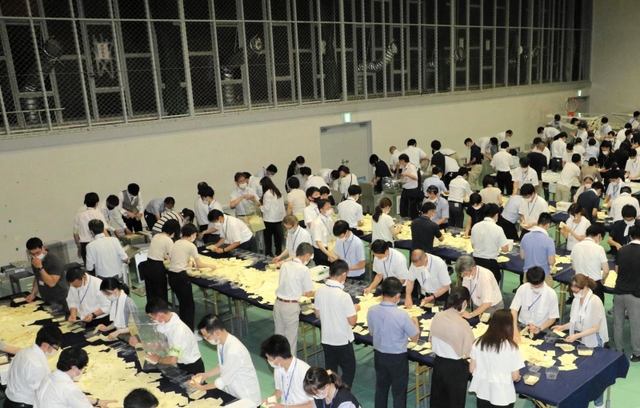 最初に投票箱から票を取り出してまとめていく「開披台」。窓から差し込まれているのが、クーラーの冷気を屋内に送り込むためのダクト＝いずれも１０日夜、神戸市東灘区甲南町５