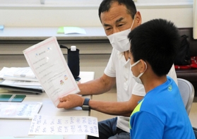 外国人の子どもに日本語を教えるボランティアの男性＝神戸市東灘区本庄町２