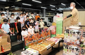 卸売会社の担当者から青果の競りの仕組みを教わる子どもたち＝神戸市東灘区深江浜町