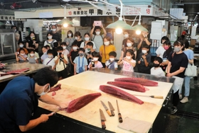 マグロの解体を見学する親子たち＝神戸市東灘区深江浜町