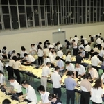 最初に投票箱から票を取り出してまとめていく「開披台」。窓から差し込まれているのが、クーラーの冷気を屋内に送り込むためのダクト＝いずれも１０日夜、神戸市東灘区甲南町５