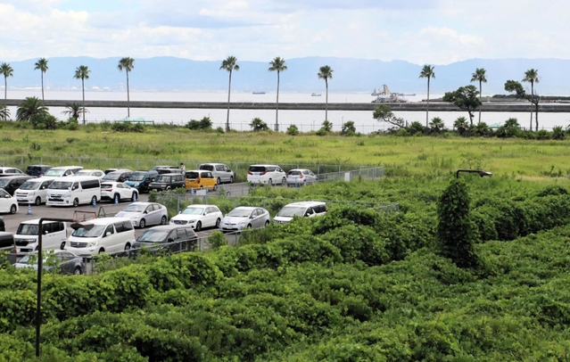 沿岸の眺望を生かし、グランピングなどの集客施設を公募することになった市有地。駐車場で使われている区画とマリンパーク（奧）の間が今回の貸付対象地になる＝神戸市東灘区向洋町中９