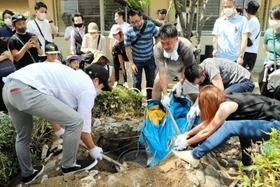 住吉小にあるミニ古墳からタイムカプセルを掘り返す１９９９年度の卒業生たち＝神戸市東灘区住吉東町４