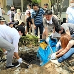 住吉小にあるミニ古墳からタイムカプセルを掘り返す１９９９年度の卒業生たち＝神戸市東灘区住吉東町４