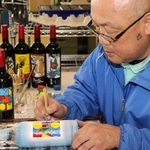 「光明兼光」の職人がイラストや模様を彫刻したボトル。１本ずつ手塗りしている＝姫路市飾磨区構