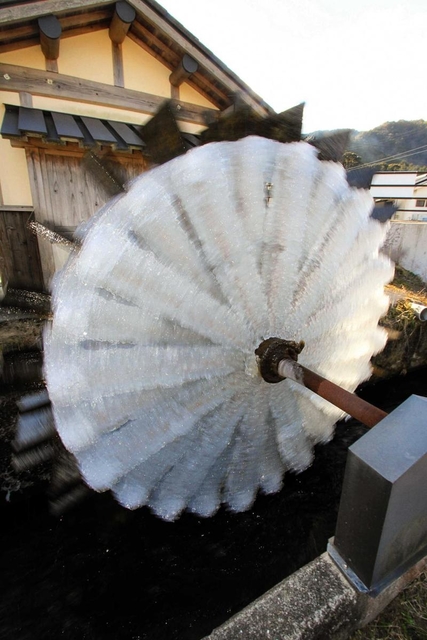 氷に覆われて輝く水車＝神河町新野