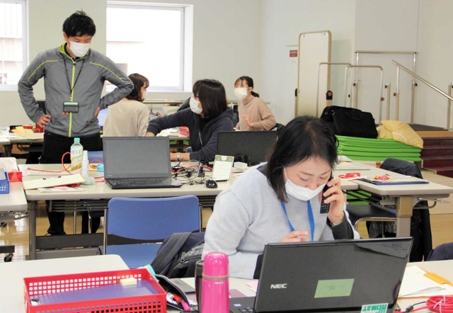 携帯電話で患者や家族に体調を聞き取る保健師ら。急きょ、訪問が決まるケースもある＝姫路市坂田町