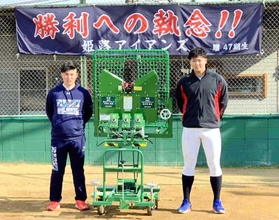 激励を受け、ピッチングマシンを贈った嘉手苅投手（右）と小深田選手＝姫路市飾磨区中島（ヤング姫路アイアンズ提供）