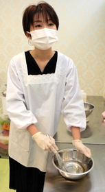 割烹着姿でせっけんを作る大島真莉菜さん＝マリーナマーメイド