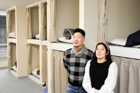 宿泊者の就寝スペースで、苦境を語る畠嘉如一さん（左）ら＝姫路市二階町、ワンホステルヒメジ