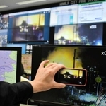 スマートフォンで撮影した映像が消防局のモニター（奥）に中継される＝姫路市三左衛門堀西の町、市消防局