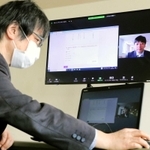 奥のモニターのように受験生の操作画面とカメラの映像が並んで表示されるのを、試験監督が遠隔でチェックする＝神戸医療福祉大学