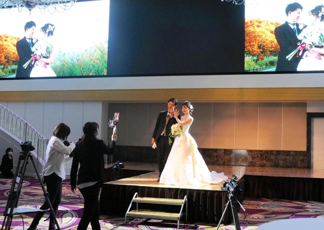 華やかなドレス姿でランウエーを歩くモデルを撮影し、ライブ配信した＝ホテルモントレ姫路