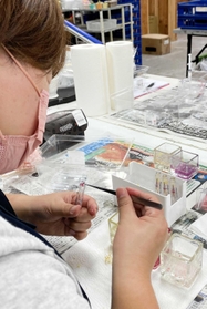 ピンセットでボールペン用の細い筒に花びらを詰めていく従業員＝サウンドスパイス