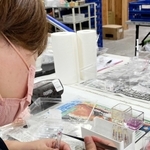 ピンセットでボールペン用の細い筒に花びらを詰めていく従業員＝サウンドスパイス