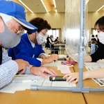 高齢者向けのワクチン接種で、姫路市役所では７日も若者による「予約お助け隊」の活動があった。２日目のこの日は大学生が中心となり、スマートフォンの苦手なお年寄りをサポート。集団接種を受けることになった夫妻は「やっと予約が取れた」と笑顔を見せた。次回の予定は未定＝姫路市安田４