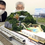 ２階にあるジオラマを見る稲田禎之さん（右）。網干総合車両所や手柄山一帯を再現した一角も＝姫路市二階町