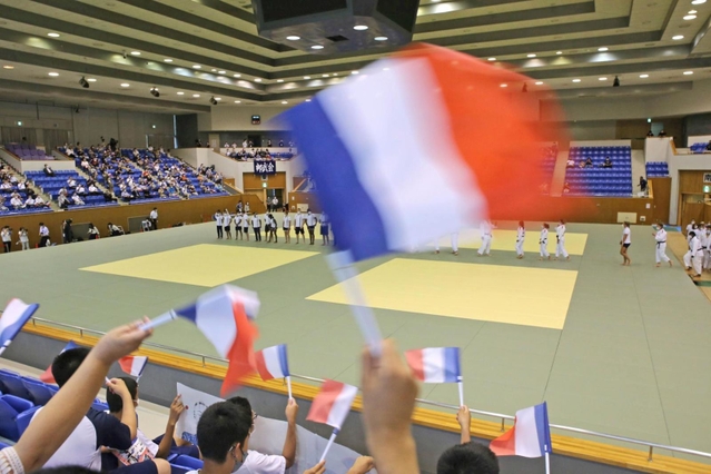 小旗を振ってフランス柔道チームの選手たちを歓迎する観客＝兵庫県立武道館