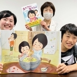 お気に入りのページを開く大和優月君といそのこつぶさん（左）ら＝姫路市内