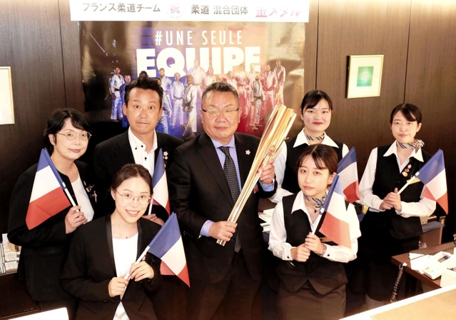 フランス選手団を迎え入れた山田篤総支配人（中央）とホテルの従業員ら。聖火リレーの点火セレモニーにも参加した＝ホテル日航姫路