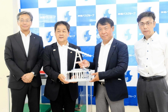 模型を寄贈する佐藤精機の佐藤慎介社長（右から２人目）＝姫路市書写、書写山ロープウェイ山麓駅