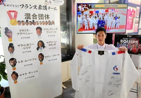 市役所１階に設けた特設コーナーでサイン入り柔道着を持つ市スポーツ振興室の白井俊輔さん＝姫路市安田４