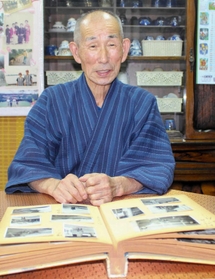 アルバムを眺めながら、幼い少年が感じた戦争を振り返る黒田さん＝姫路市