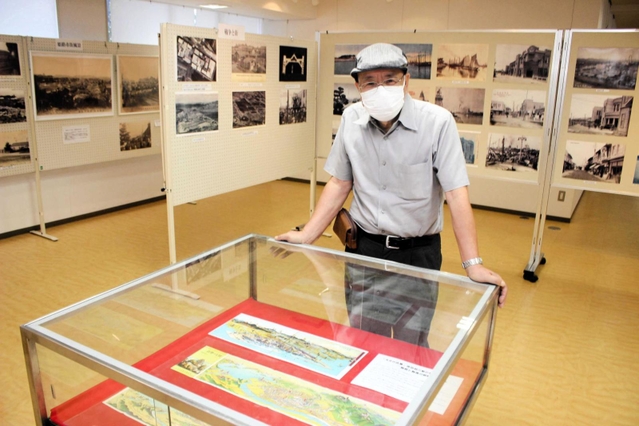 懐かしい写真が並ぶ会場と福井孝幹さん＝見野の郷交流館