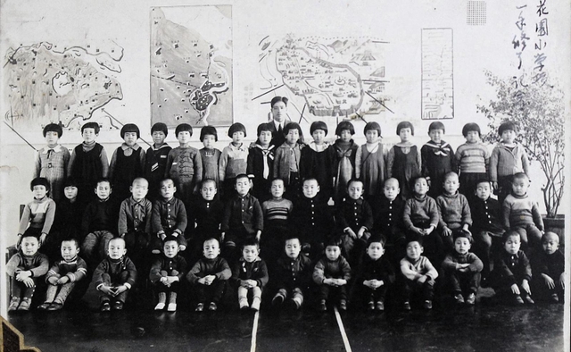 ハルビンの国民学校で同級生と写真に納まる田郷さん（上段左から５人目、提供）