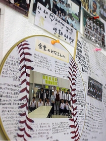 食堂の壁に張られた卒業生らからの寄せ書きや写真＝姫路市飾西