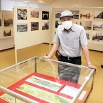 懐かしい写真が並ぶ会場と福井孝幹さん＝見野の郷交流館