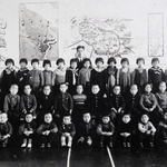 ハルビンの国民学校で同級生と写真に納まる田郷さん（上段左から５人目、提供）