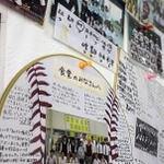 食堂の壁に張られた卒業生らからの寄せ書きや写真＝姫路市飾西