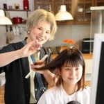 布施愛貴さん宅で髪を切る山口絵梨香さん（左）＝姫路市内