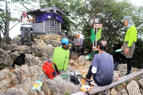 大天井岳山頂で登山者と談笑する植田さん（左）＝姫路市夢前町山之内