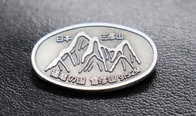 植田将志さんが売り歩く雪彦山の登山バッジ