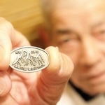 植田将志さんが売り歩く雪彦山のバッジ＝姫路市白銀町