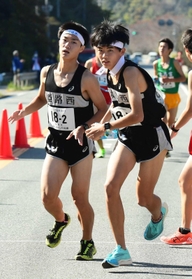 男子・姫路西の２区森大樹選手（左）からたすきを受け取る３区曽賀大登選手＝丹波篠山市内（撮影・坂井萌香）