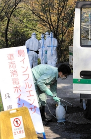 車両を消毒する関係者。家畜保健衛生所の職員らも防護服姿で鶏舎へと向かった＝姫路市内（撮影・大山伸一郎）