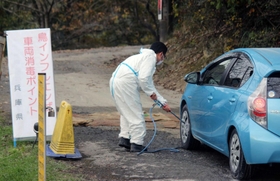 県が設けたポイントで車両を消毒する職員。当面は同様の対応が続けられる＝姫路市内（撮影・山本　晃）