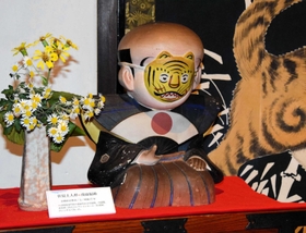 長尾善三さんのコレクションの一つ、虎の面をかぶった福助人形。収集部屋「狂虎洞」のシンボルだった＝日本玩具博物館