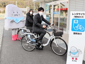 レンタサイクルの営業開始をアピールする町職員らと「ぼうじぃ」＝姫路市網干区和久