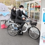 レンタサイクルの営業開始をアピールする町職員らと「ぼうじぃ」＝姫路市網干区和久